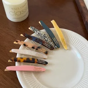 Lot de huit barrettes en acétate aux motifs marbrés et écailles sur un plateau élégant