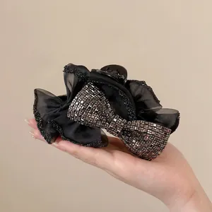 Elegante molletta per capelli con fiocco di paillettes nere e strass in rete velata