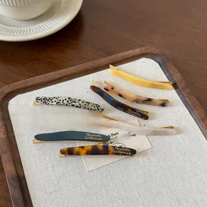 Détail du lot de 8 barrettes en acétate avec gravure du logo doré Barrette LaFrance