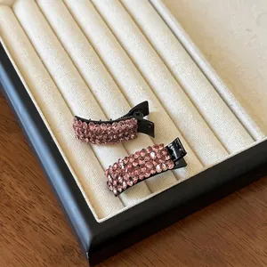 Close-up of sparkling pink crystal rhinestones set on two pieces of elegant hair clips