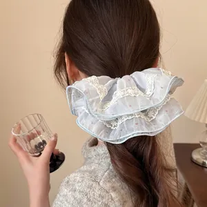Blue tulle lace scrunchie with red dots on a ponytail, sweet vintage style for women