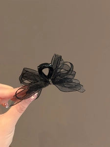 Detailed close-up of a black organza ribbon hair claw clip with delicate rhinestone center