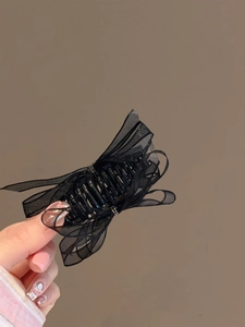 Detail of elegant black organza bow hair claw clip with sparkling crystal accents