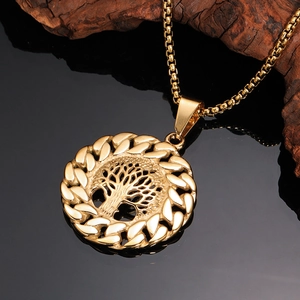 Golden Tree of Life necklace with cutout pendant and box chain on black mirror