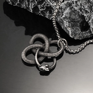 Macro view of vintage stainless steel Ouroboros snake pendant with detailed scales texture