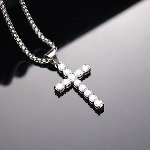 Detailansicht eines silbernen Kreuzanhängers mit Diamanten an einer Box-Kette