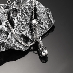 Collier punk gothique avec double pendentif tête de mort en acier sur roche grise