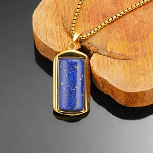 Macro-opname van de gouden lapis lazuli hanger met boxketting op donkere houten basis