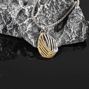 Détail macro du pendentif goutte torsadé bohème avec zircons jaunes sur chaîne box