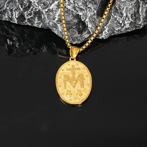 Gros plan détaillé du pendentif religieux ovale doré avec croix et étoiles gravées