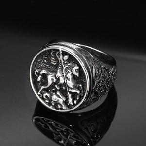 Detail of vintage punk St. George dragon slayer ring with intricate vine carvings