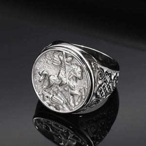 Macro shot of silver punk ring showing detailed St George portrait and floral carvings