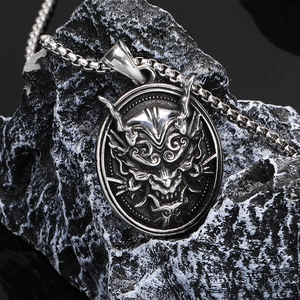 Vintage stainless steel Hannya pendant necklace with dark gothic aesthetic on stone