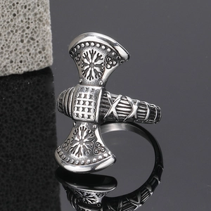 Macro shot of Viking battle axe ring with Nordic rune engravings on a reflective surface