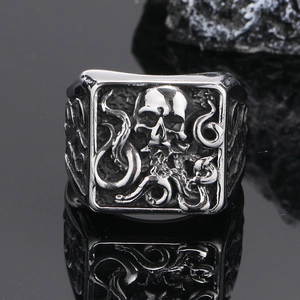 Gros plan d'une bague gothique tête de mort poulpe avec gravures et reflets pierre noire