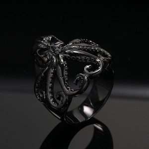 Macro detail of gothic octopus ring with skull head and textured tentacles on black background