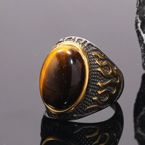 Macro detail of men's tiger eye ring featuring golden flame carvings on vintage steel