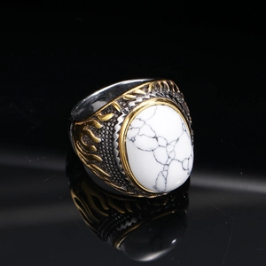 Macro shot of punk style steel ring with white turquoise stone and flame carvings