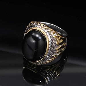 Detailed close-up of retro punk titanium steel ring with black oval gem and gold carving