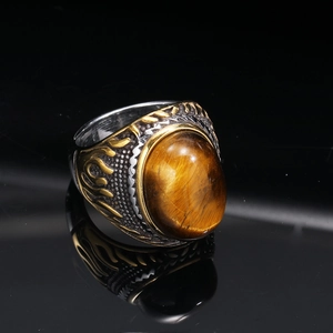Macro view of vintage tiger eye stone ring with golden flame relief carvings