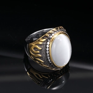 Macro shot of punk style ring with oval white opal stone and gold flame relief details