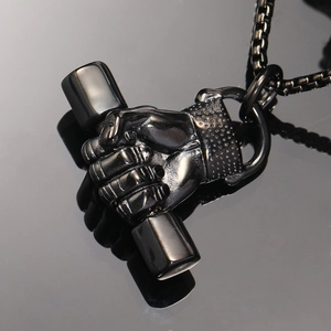 Détail macro du pendentif haltère avec poing et chaîne à mailles carrées noire polie