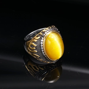 Macro view of vintage titanium ring with yellow cat eye stone and gold flame relief