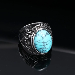 Detailed close-up of retro silver ring with oval turquoise stone and flame carvings