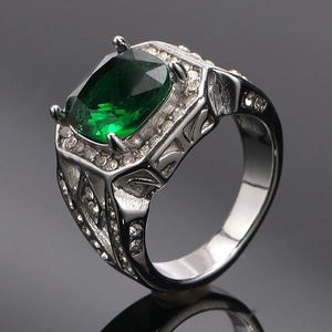 Macro view of emerald-cut green stone ring with silver setting and pavé diamonds