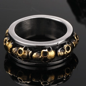 Gothic skull ring for men with silver band and gold embossed relief in punk rock style