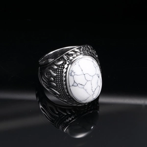 Macro detail of vintage punk titanium steel ring with white marble stone and leaf texture