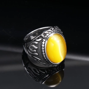 Macro shot of punk flame-patterned titanium steel ring with yellow cat-eye gemstone