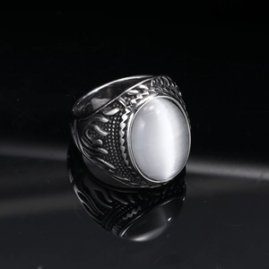 Detail of vintage punk ring featuring a white cat eye stone and flame relief carving