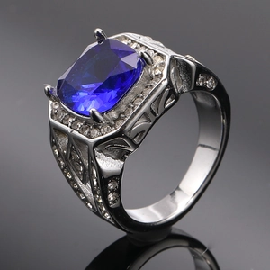 Macro shot of silver ring featuring a large cushion-cut blue stone and zircon accents