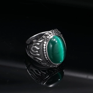 Macro shot of vintage titanium ring with green cat eye gemstone and flame carvings