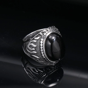 Detail view of vintage punk ring featuring a black oval gemstone and flame carvings