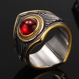 Détail macro de la texture plume rétro avec pierre rouge sur bague en acier inoxydable