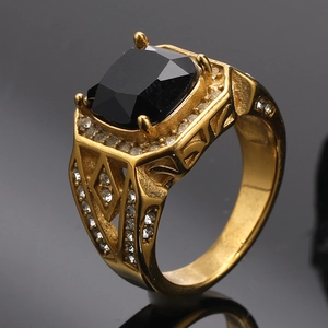Close-up of golden ring with rectangle black stone and hollow diamond patterns