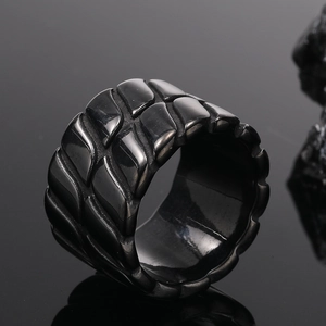 Makroaufnahme eines schwarzen Titanstahl-Herrenrings mit Schuppenmuster und glatter Innenseite