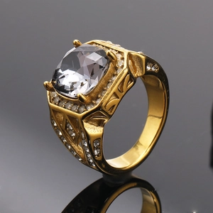 Detail view of gold ring with cushion-cut clear stone and intricate side engraving