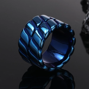 Makroaufnahme blauer Titanstahlring mit industrieller Schuppenstruktur und dunklen Schatten
