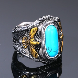 Detalle macro de anillo vintage para hombre con turquesa y grabado de águila dorada