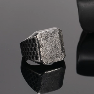 Macro shot of vintage silver steel ring with hammered texture and honeycomb pattern