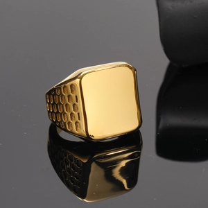 Men's gold rectangular signet ring with geometric honeycomb texture on black mirror