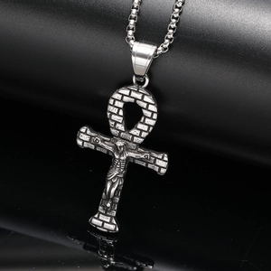 Detailed view of silver Ankh cross pendant with relief texture on black leather surface