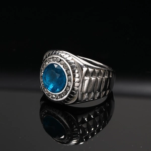 Macro detail van herenring van titaniumstaal met ovale blauwe edelsteen en zijtexturen
