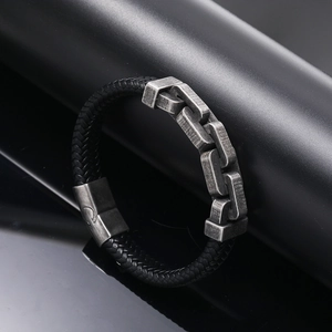 Dettaglio macro del bracciale in pelle intrecciata da uomo con catena e chiusura magnetica