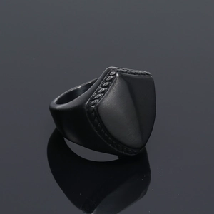 Macro shot of black matte shield ring with braided rope texture and reflective finish
