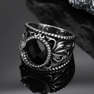 Macro shot of gothic style silver ring with black faceted gemstone and hollow texture