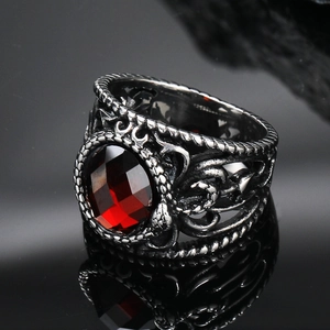 Macro shot of vintage titanium steel ring featuring red gemstone and ornate engraving